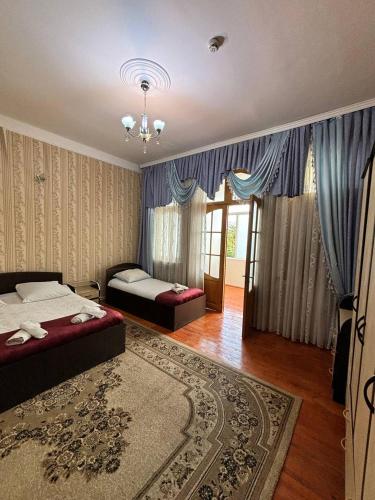 a bedroom with two beds and a rug at STOP otel in Sheki