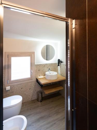 a bathroom with a sink and a toilet and a mirror at Chioggia Rooms in Chioggia