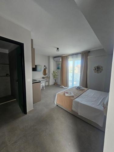 a bedroom with a large bed and a kitchen at 9muses luxury rooms in Vasiliki