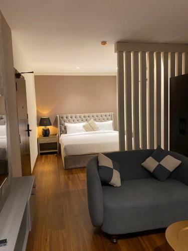 a living room with a bed and a couch at The Address Boutique Hotel Karachi in Karachi