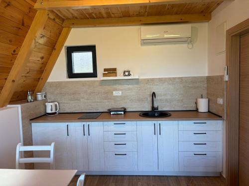 a kitchen with white cabinets and a sink at Maple Valley in Žabljak