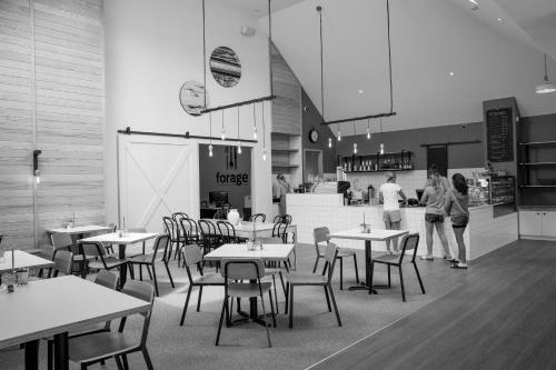 two women standing in a restaurant with tables and chairs at The Harvest Hotel in Cromwell