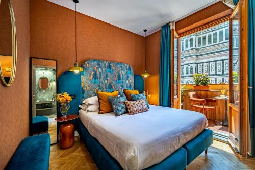 a bedroom with a bed with a blue headboard at Hotel Duomo Firenze in Florence