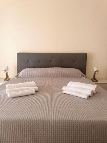 a bed with two white towels on it with two lamps at Mimmo Wanderlust in Mazzeo
