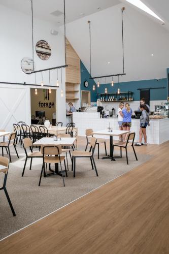 a restaurant with tables and chairs and people in the background at The Harvest Hotel in Cromwell