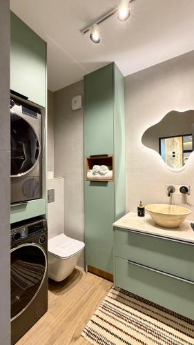 a bathroom with a sink and a washing machine at River View Penthouse & Jacuzzi in Reghin