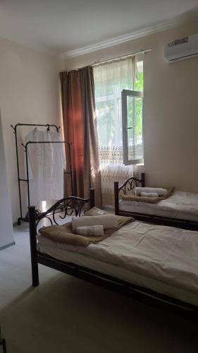 two beds in a room with a window at Oni Guesthouse in Oni