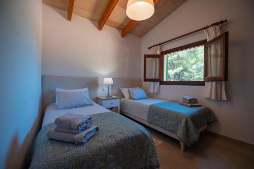 a bedroom with two beds and a window at Maricel in Cala Ratjada