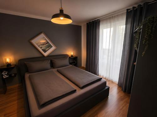 a bed in a bedroom with a large window at Fewo Lago di Costanza I in Friedrichshafen