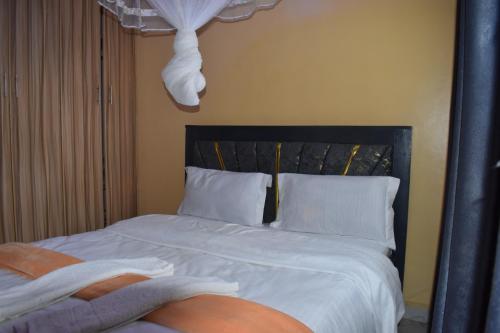 a bedroom with a bed with white sheets and pillows at Unique Place 1 Bedroom Thika in Thika