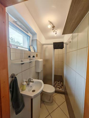 a small bathroom with a sink and a toilet at Napsugár Vendégház Velence in Velence