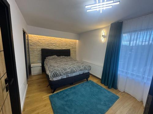 a bedroom with a bed and a blue rug at Casa DAVIANA in Luna de Sus