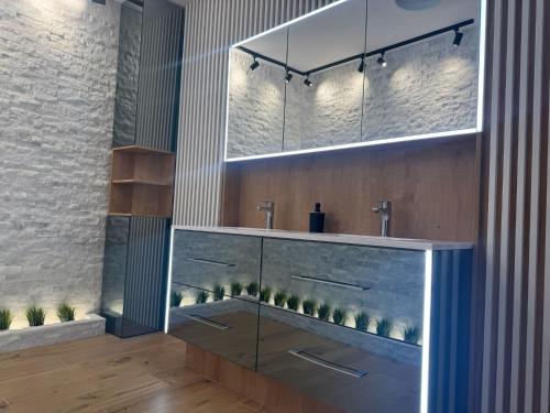 a bathroom with two sinks and two mirrors at Casa DAVIANA in Luna de Sus
