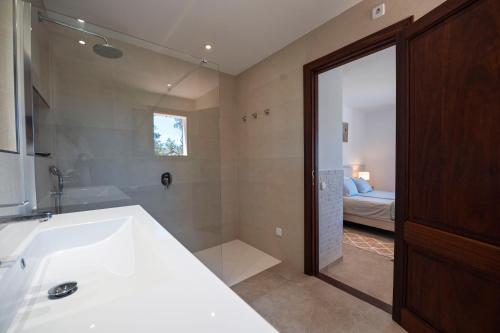 a bathroom with a sink and a tub and a bed at Maricel in Cala Ratjada