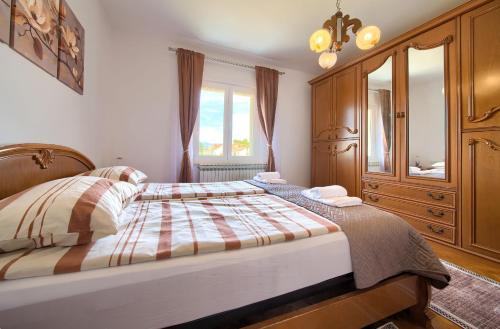 a bedroom with a large bed and a dresser at Apartman Pina in Vrbnik