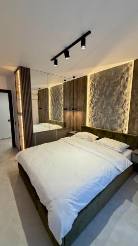 a bedroom with a large white bed and a bathroom at River View Penthouse & Jacuzzi in Reghin