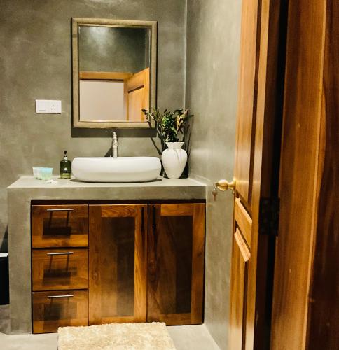 a bathroom with a sink and a mirror at Gedara Boutique in Katunayaka