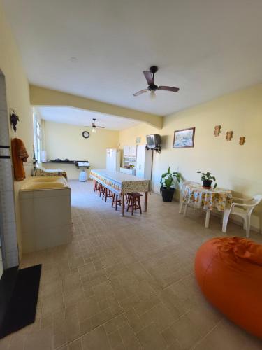 a living room with tables and chairs and a ceiling at Suíte independente com cozinha e varanda in Piúma