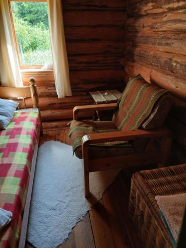 a room with a chair and a window in a log cabin at Pähnamäe metsamajake in Ruusmäe