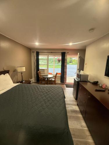 a bedroom with a bed and a table with a television at Nites Inn Motel in Cornwall