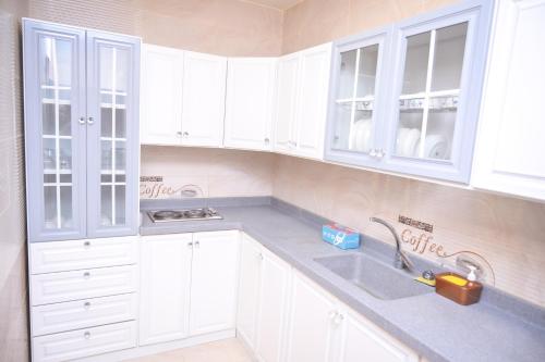 a kitchen with white cabinets and a sink at روعة نجد المغرزات in Riyadh