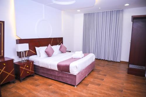 a bedroom with a large bed with white sheets and pink pillows at روعة نجد المغرزات in Riyadh