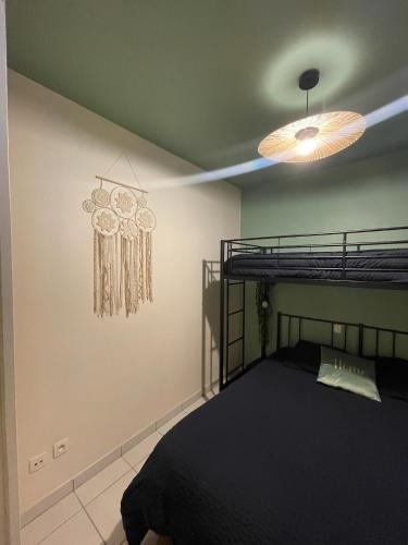 a bedroom with a black bed and a ceiling at Bulle d amour in Granville