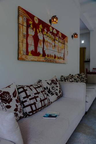 a living room with a white couch with pillows at Everdew Kandy in Kandy
