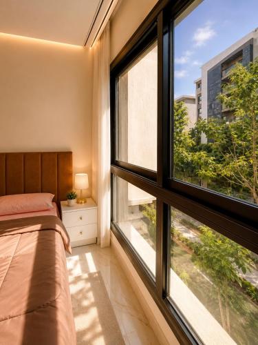 a bedroom with a bed and a large window at Stunning view in Madinaty in Madinaty