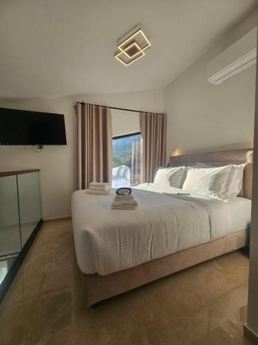 a bedroom with a large white bed with a window at Sage Villas in Plataria