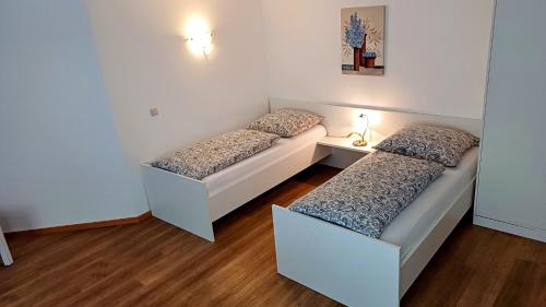 a room with two beds and a table with a lamp at Ferienwohnung Maria in Hörnsheim