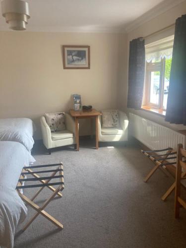 a bedroom with a bed and a table and chairs at Islandview House in Clonbur