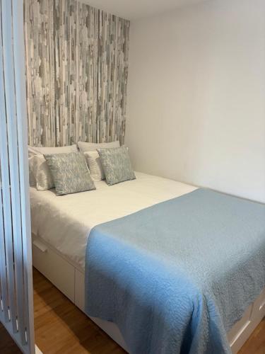 a bedroom with a bed with a blue blanket at My Little Beach House in Praia da Barra