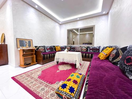 a living room with a purple couch and a table at Apartment in Azemmour in Azemmour