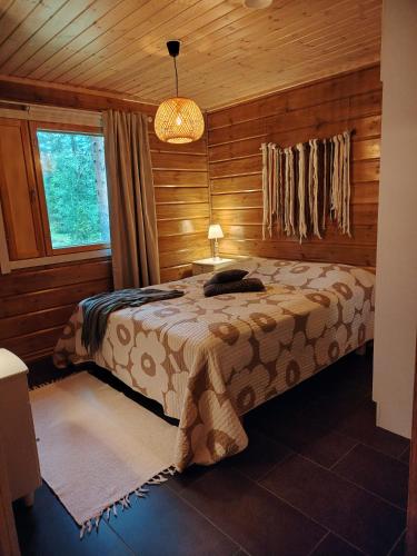 a bedroom with a bed in a wooden cabin at Villa Goahti - Kantokelo in Ylläsjärvi