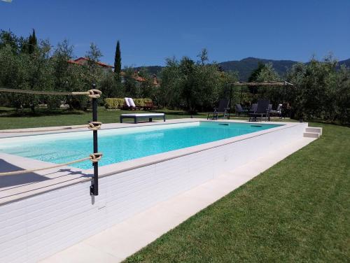 a swimming pool in a yard next to a field at Il Piccolo Oliveto in Arezzo