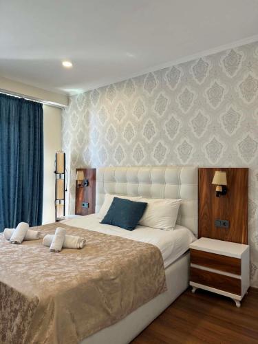 a bedroom with a large white bed with blue pillows at The Fresh Wave hotel in Batumi