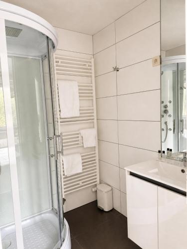 ein weißes Badezimmer mit Dusche und Waschbecken in der Unterkunft Lavan in Löwen