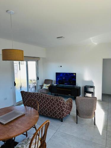 a living room with a couch and a table and a piano at Los Agapanthus in General Belgrano
