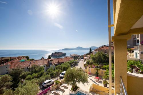 a view of a town with the ocean in the background at BMV TRIPLE ROOM WITH BALCONY in Sveti Stefan