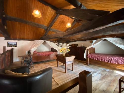 a living room with two beds and a table at Gîte de Calouze - 5 personnes in Gijounet