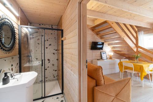 a bathroom with a shower and a sink and a table at Domki Błękitne Nad Morzem Międzywodzie in Międzywodzie