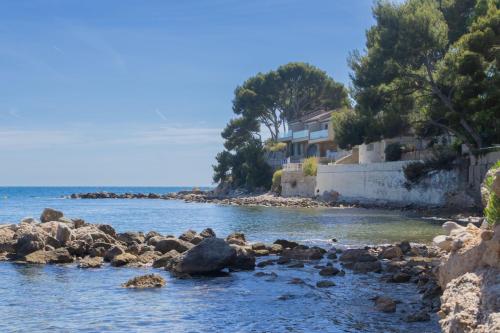 a river with rocks in front of a house at Duplex de Bandol - Plages et port à pied in Bandol