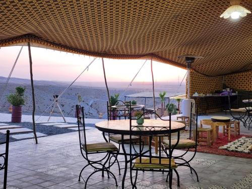 a patio with a table and chairs with a view at Travel sky morocco camp in El Karia