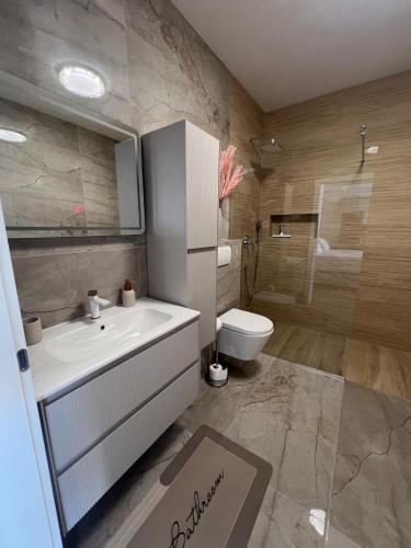a bathroom with a white sink and a toilet at Guest House Gabi in Srima