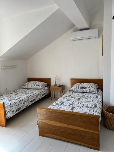two beds in a room with white walls at Apartmani MM Trebinje in Trebinje