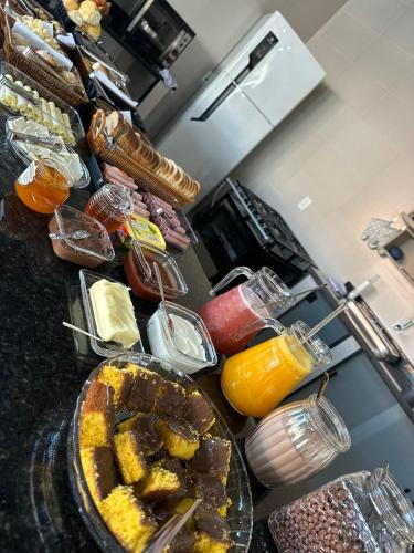 a kitchen counter with a bunch of food on it at Suite com cozinha 250m do centro in São Thomé das Letras