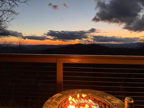 a pizza cooking in a grill with the sunset in the background at Calling Me Home in Lenoir