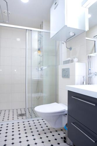 a bathroom with a shower and a toilet and a sink at Hotel Amandis in Naantali