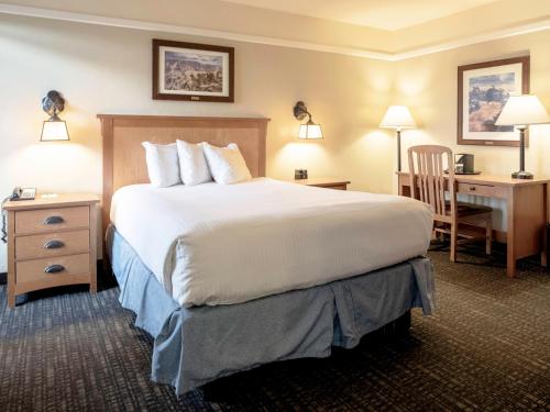 a hotel room with a large bed and a desk at El Tovar - Inside the Park in Grand Canyon Village